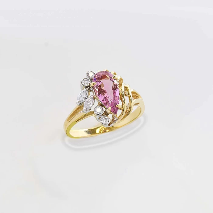 14K yellow gold ring with pear-shaped pink tourmaline and surrounding white diamonds in an elegant cluster design